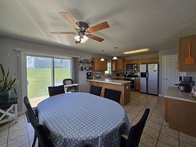 dining space featuring a ceiling fan, light tile patterned flooring, and a healthy amount of sunlight