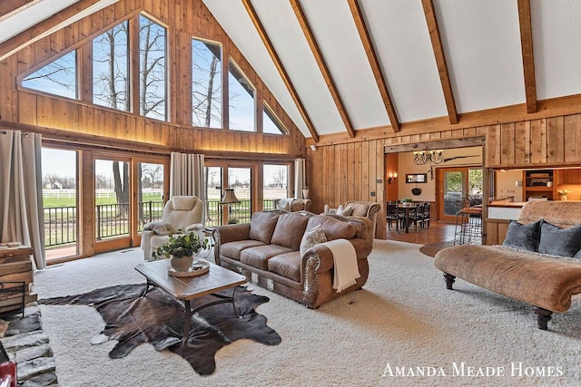 living room with high vaulted ceiling, carpet floors, wood walls, and beam ceiling