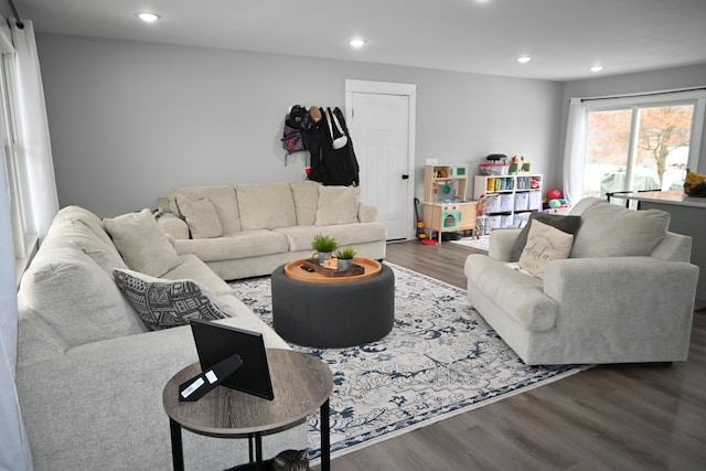 living room with recessed lighting and dark wood-type flooring