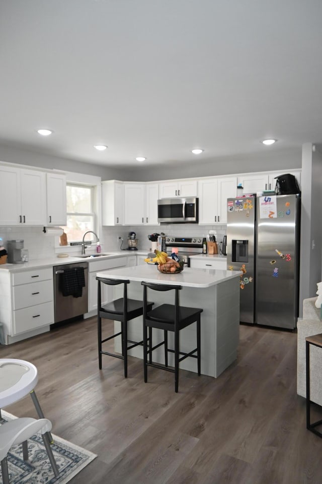 kitchen with white cabinetry, backsplash, and stainless steel appliances