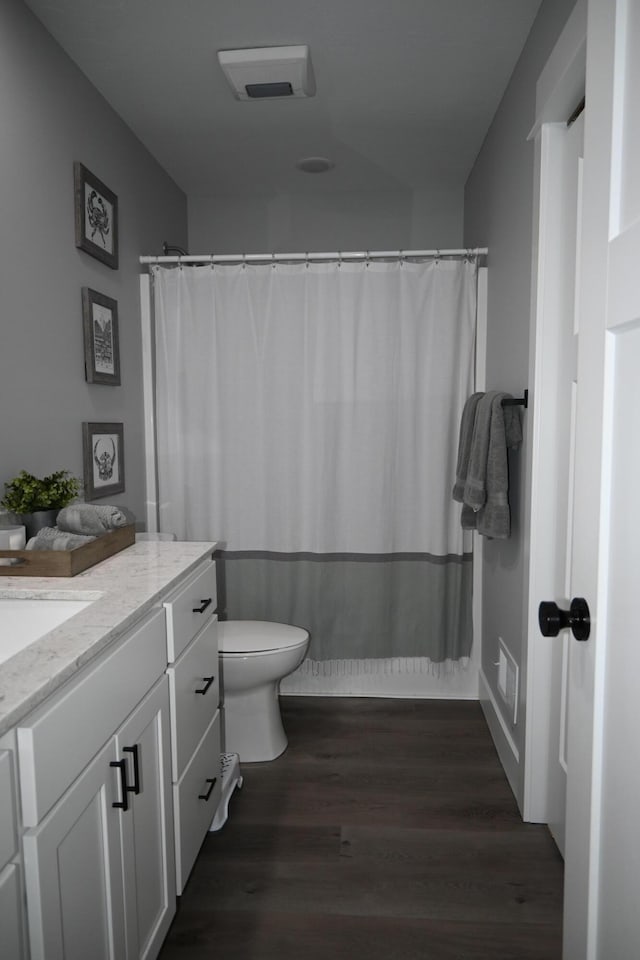 bathroom with vanity, wood finished floors, visible vents, and toilet