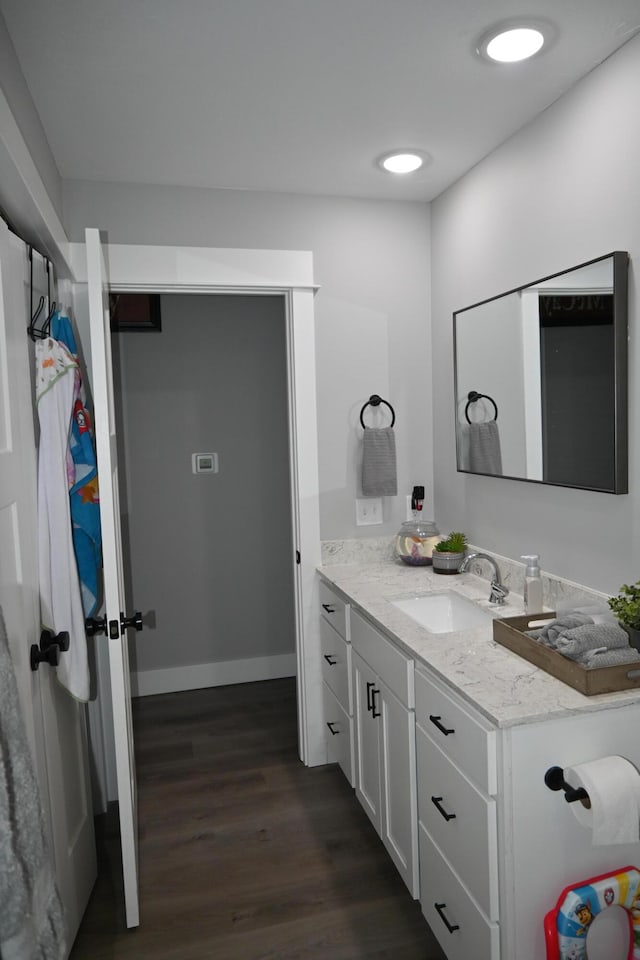 bathroom featuring vanity, baseboards, and wood finished floors