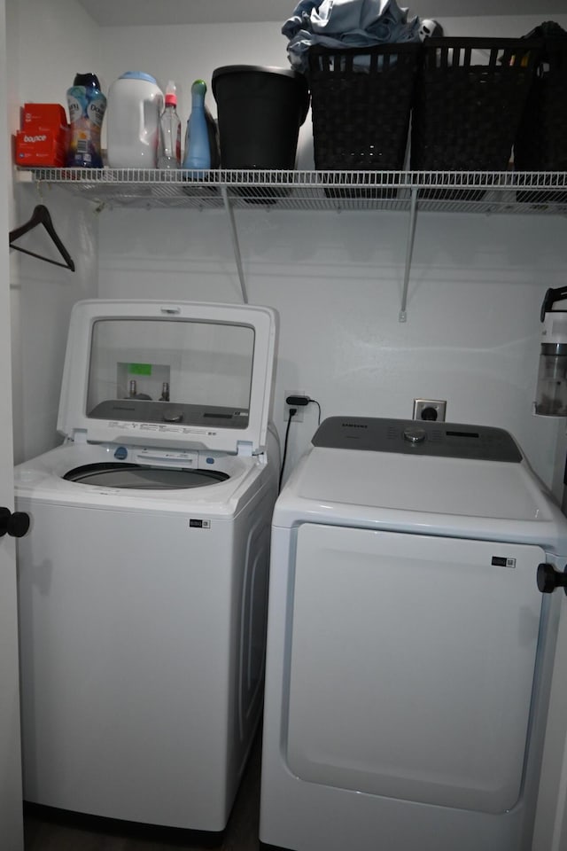 clothes washing area with independent washer and dryer and laundry area