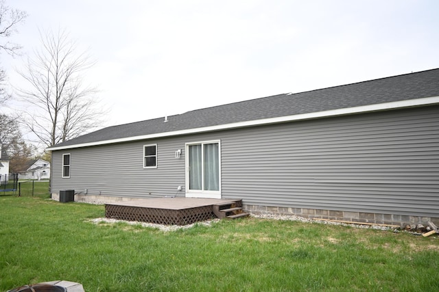 rear view of property with a yard, a deck, central AC, and fence