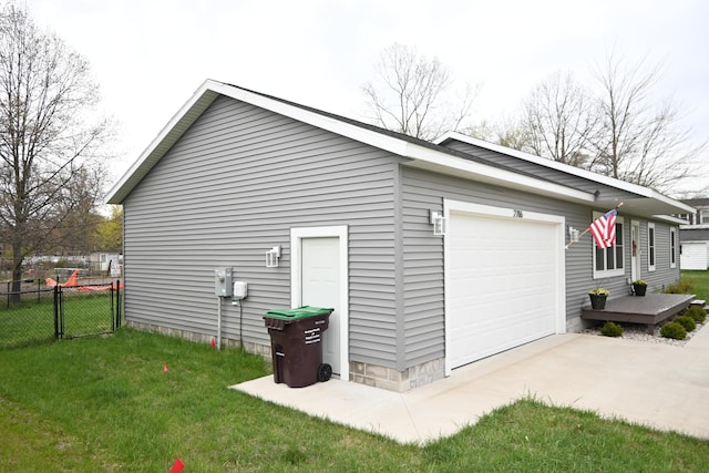 view of side of property featuring a lawn, fence, and driveway