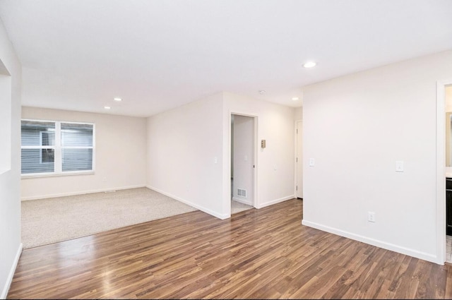 spare room with recessed lighting, baseboards, wood finished floors, and visible vents