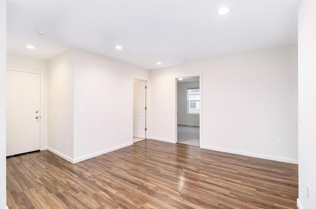 spare room featuring baseboards, recessed lighting, and wood finished floors