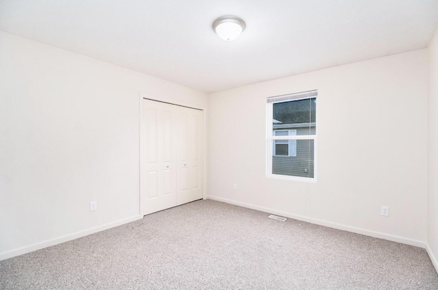 unfurnished room featuring baseboards, carpet flooring, and visible vents