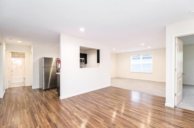 unfurnished living room with baseboards, recessed lighting, and wood finished floors