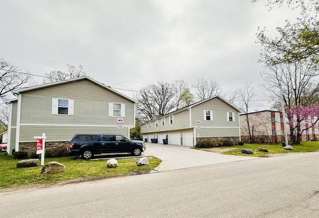 1201 Kimbark Ave, Kalamazoo, MI 49006 - view of property exterior with a garage, a yard, concrete driveway, and stone siding