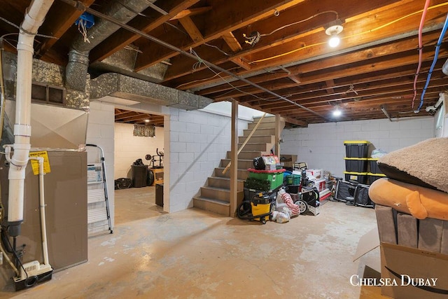 unfinished below grade area featuring concrete block wall and stairs