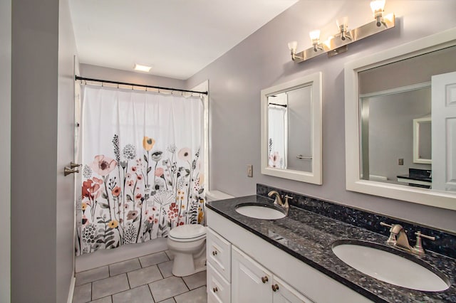 full bath with double vanity, toilet, a sink, and tile patterned flooring