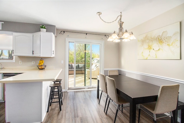 dining area featuring baseboards, a chandelier, and wood finished floors