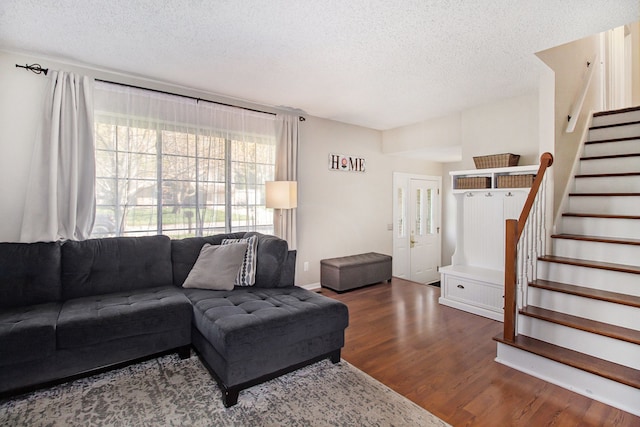 living room with stairway, a textured ceiling, and wood finished floors