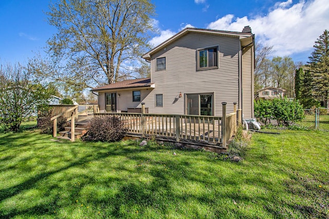 back of property featuring a lawn, a wooden deck, a chimney, and fence