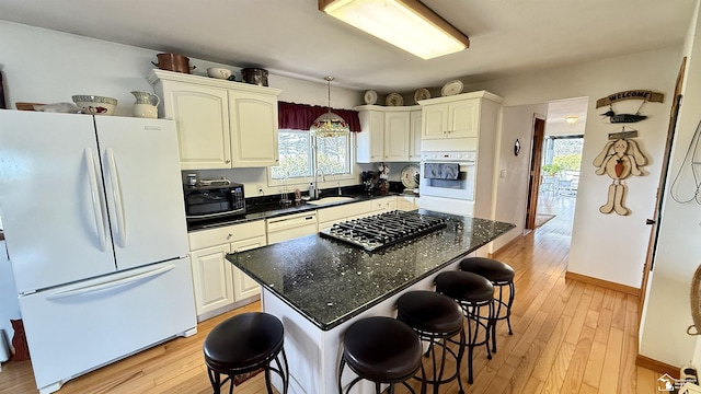 7736 S Custer Rd, Monroe, MI 48161 - kitchen with white appliances, a breakfast bar, a wealth of natural light, and a sink
