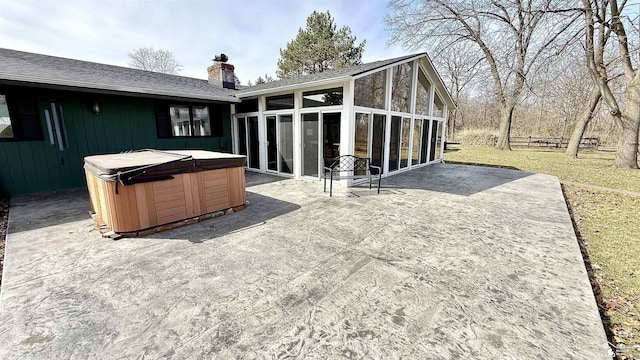 7736 S Custer Rd, Monroe, MI 48161 - rear view of property featuring a shingled roof, a hot tub, a sunroom, a chimney, and a patio