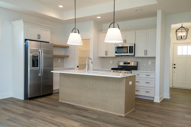 kitchen featuring a sink, light countertops, dark wood finished floors, stainless steel appliances, and decorative backsplash