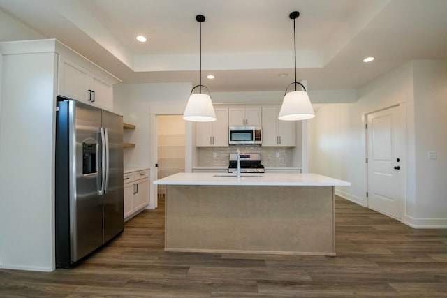 kitchen featuring dark wood-style floors, light countertops, a raised ceiling, appliances with stainless steel finishes, and backsplash