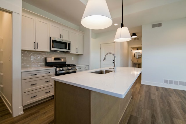kitchen with a sink, stainless steel appliances, dark wood-style floors, and visible vents