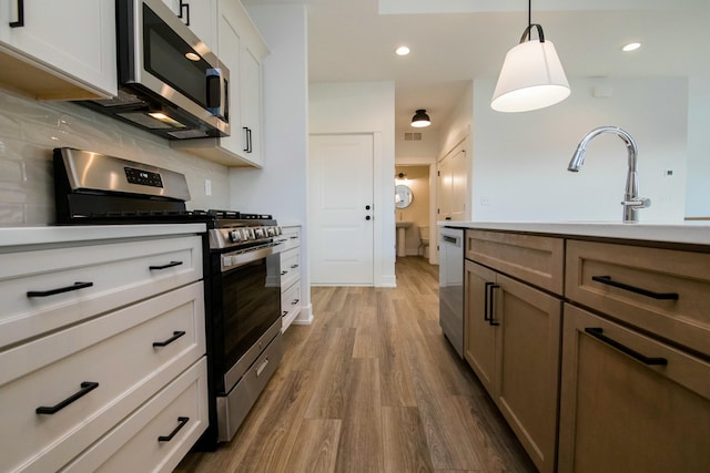 kitchen with stainless steel appliances, decorative light fixtures, recessed lighting, decorative backsplash, and wood finished floors
