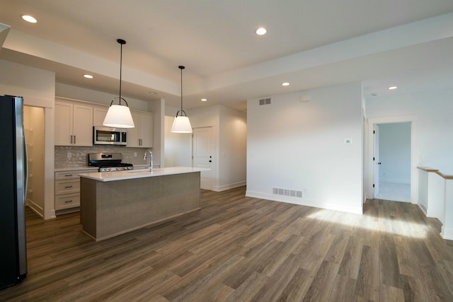kitchen featuring visible vents, dark wood-type flooring, appliances with stainless steel finishes, and backsplash