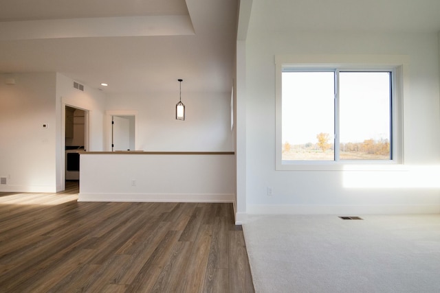 empty room with baseboards, wood finished floors, and visible vents
