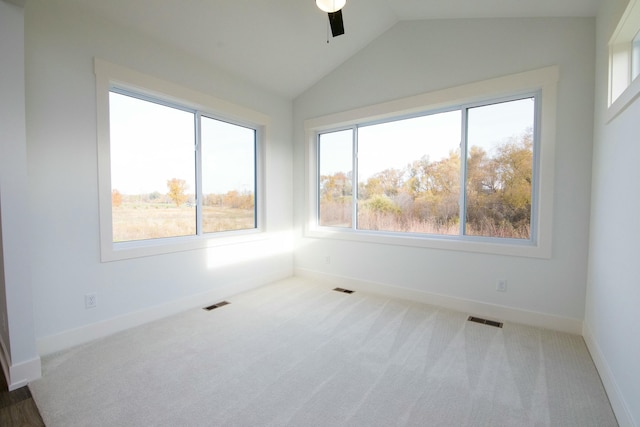 carpeted empty room with a ceiling fan, lofted ceiling, and visible vents