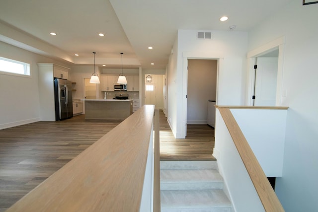 staircase with recessed lighting, baseboards, visible vents, and wood finished floors