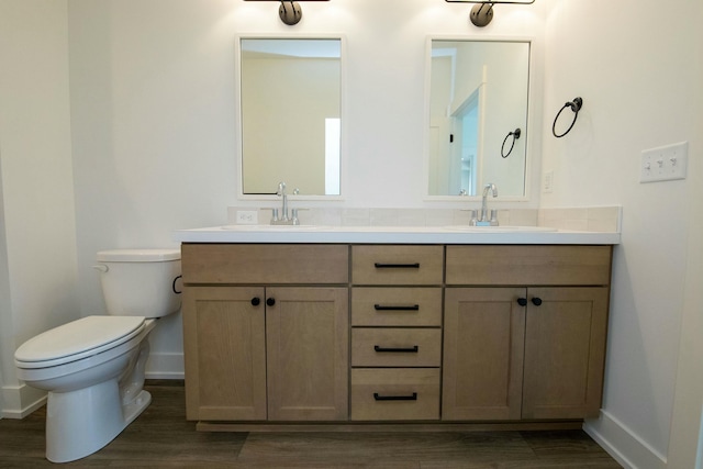 full bathroom with baseboards, a sink, wood finished floors, and toilet
