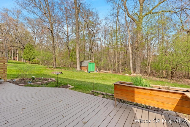 wooden deck featuring a storage shed, a yard, and an outdoor structure