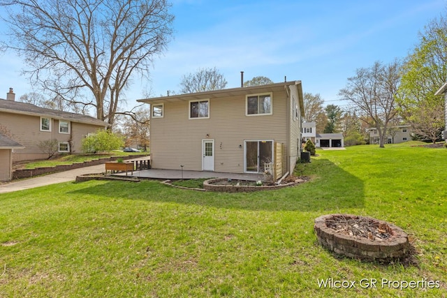 rear view of house featuring a yard, a fire pit, and a patio area