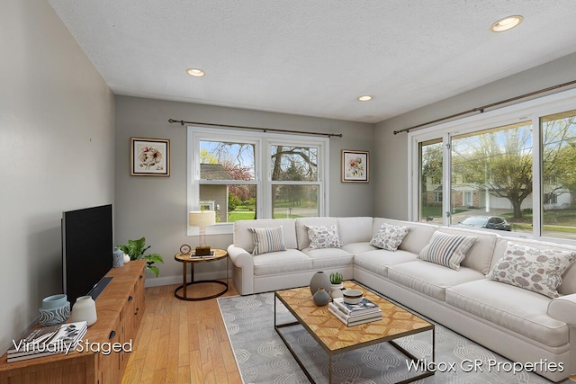 living area featuring recessed lighting, baseboards, a healthy amount of sunlight, and hardwood / wood-style flooring