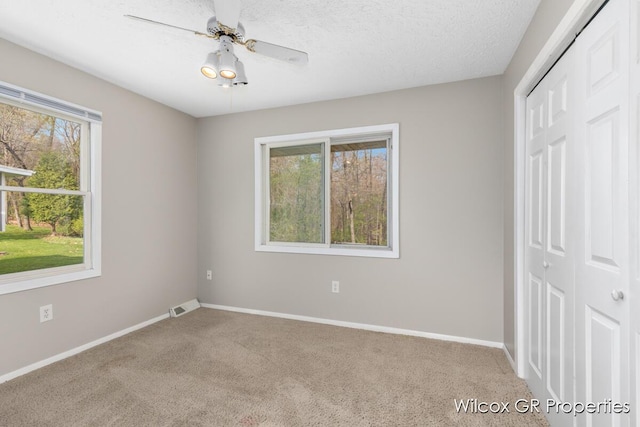unfurnished bedroom with a closet, carpet flooring, baseboards, and visible vents