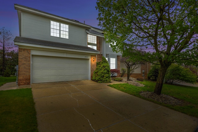 traditional-style house featuring a garage, brick siding, and driveway