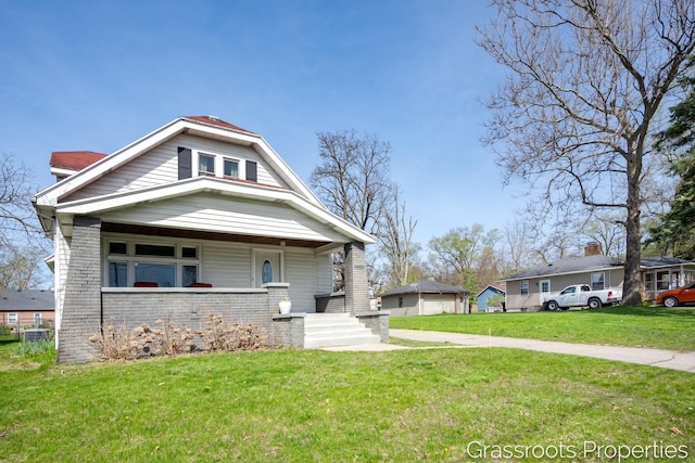 bungalow-style house featuring brick siding, a front lawn, and covered porch