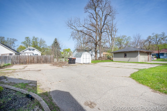 view of yard featuring an outdoor structure, a shed, and fence