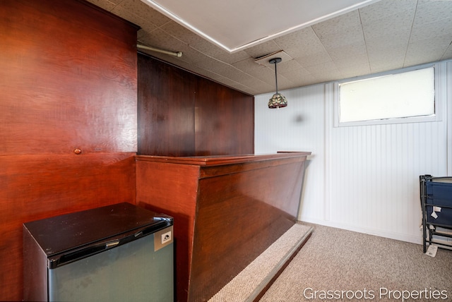 bar featuring carpet and fridge