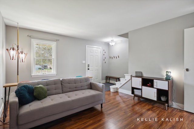 living area with baseboards, wood finished floors, and stairway
