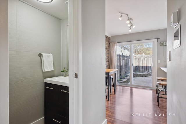 bathroom featuring vanity, rail lighting, and wood finished floors