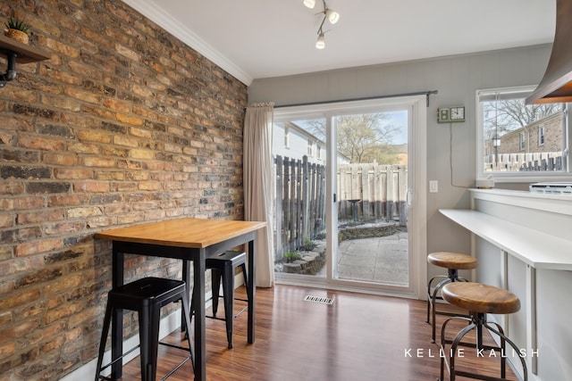 dining room featuring visible vents, wood finished floors, and a healthy amount of sunlight