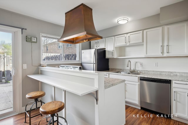 kitchen featuring a sink, appliances with stainless steel finishes, island exhaust hood, and white cabinetry