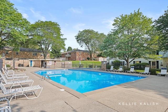 community pool featuring fence and a patio area