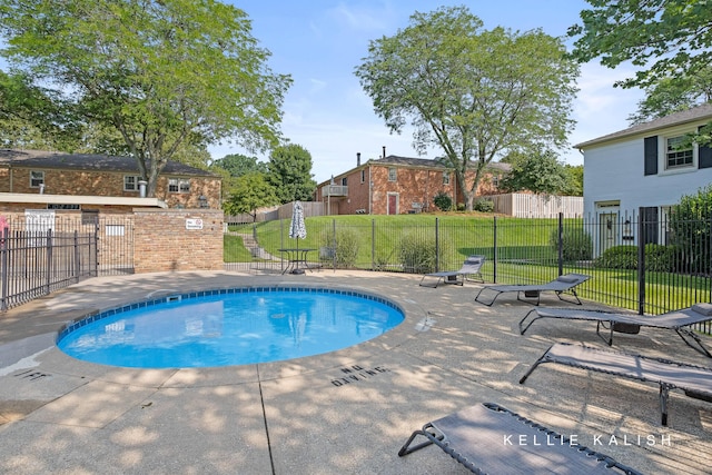 community pool featuring a yard, a patio, and fence