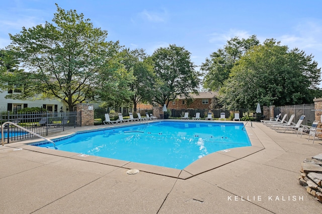 community pool featuring a patio and fence