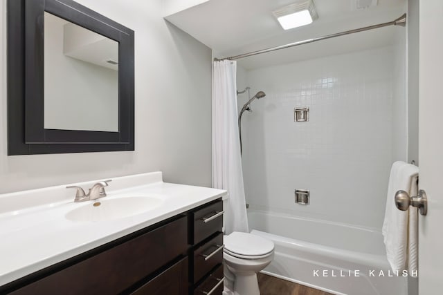 bathroom with visible vents, wood finished floors, shower / tub combo, vanity, and toilet