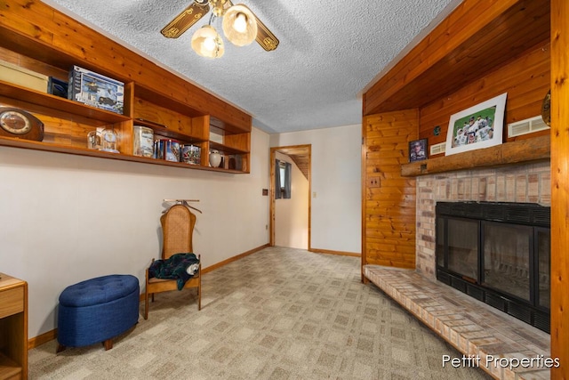 unfurnished room featuring baseboards, a ceiling fan, a textured ceiling, and a brick fireplace