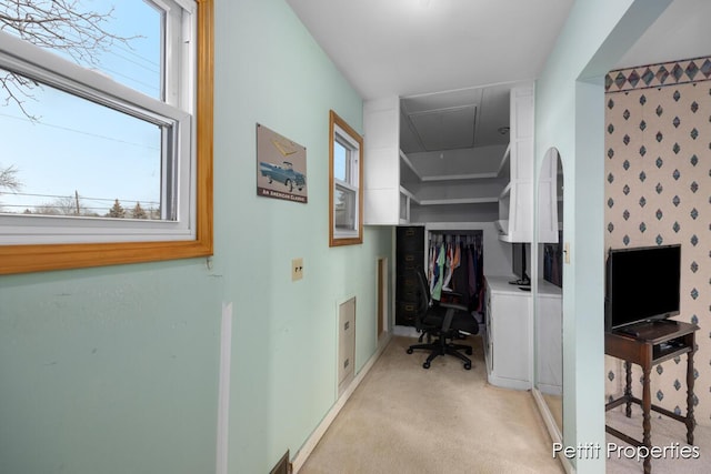 office space featuring baseboards, light colored carpet, and attic access