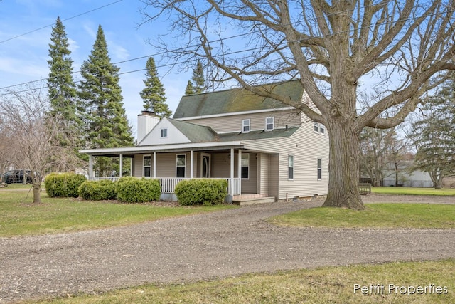 view of front of property featuring covered porch, a chimney, a front yard, and dirt driveway