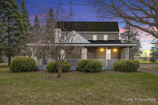 farmhouse inspired home with covered porch and a front lawn